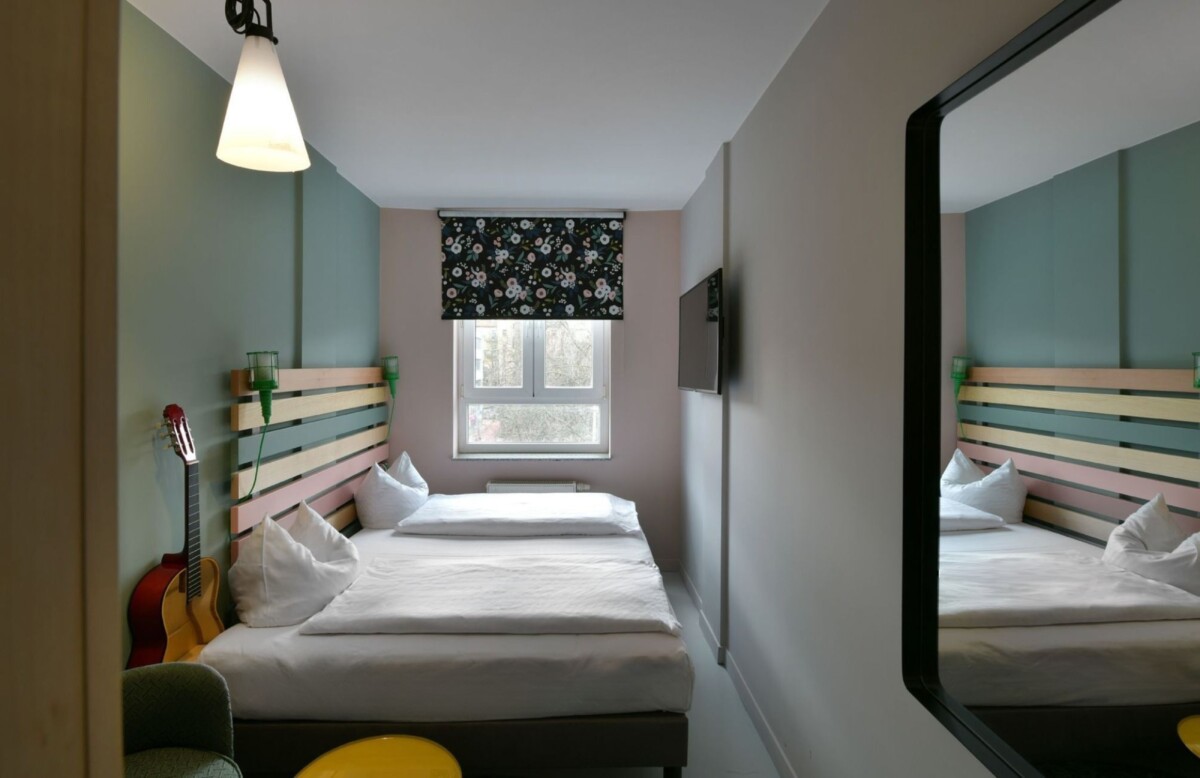 Small single hotel room with floral decor and wood accents